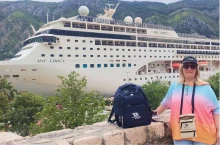 Senhora com uma mochila em frente a um navio